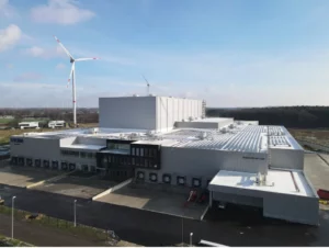 Luchtfoto van het distributiecentrum van Livlina, met een windturbine.